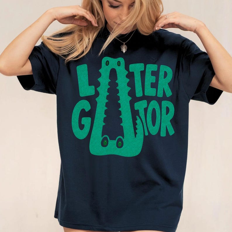 TRUE NAVY Comfort Colors graphic tee featuring a playful Later Gator alligator illustration forming the letter A in chunky retro green typography.