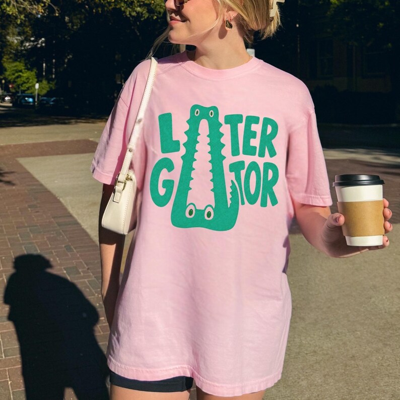 BLOSSOM light pink Comfort Colors  graphic tee featuring a playful Later Gator alligator illustration forming the letter A in chunky retro green typography.