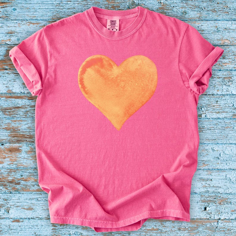Comfort Colors pink t-shirt with watercolor orange heart design in blossom and crunchberry pink.