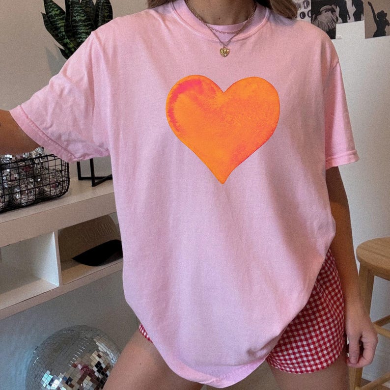 Comfort Colors pink t-shirt with watercolor orange heart design in blossom and crunchberry pink.