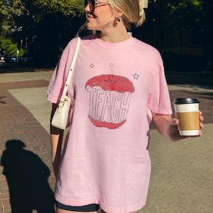 Soft pink teacher t shirt with hand sketched apple core and TEACH text, artsy minimalist teacher shirt with child drawn vintage look