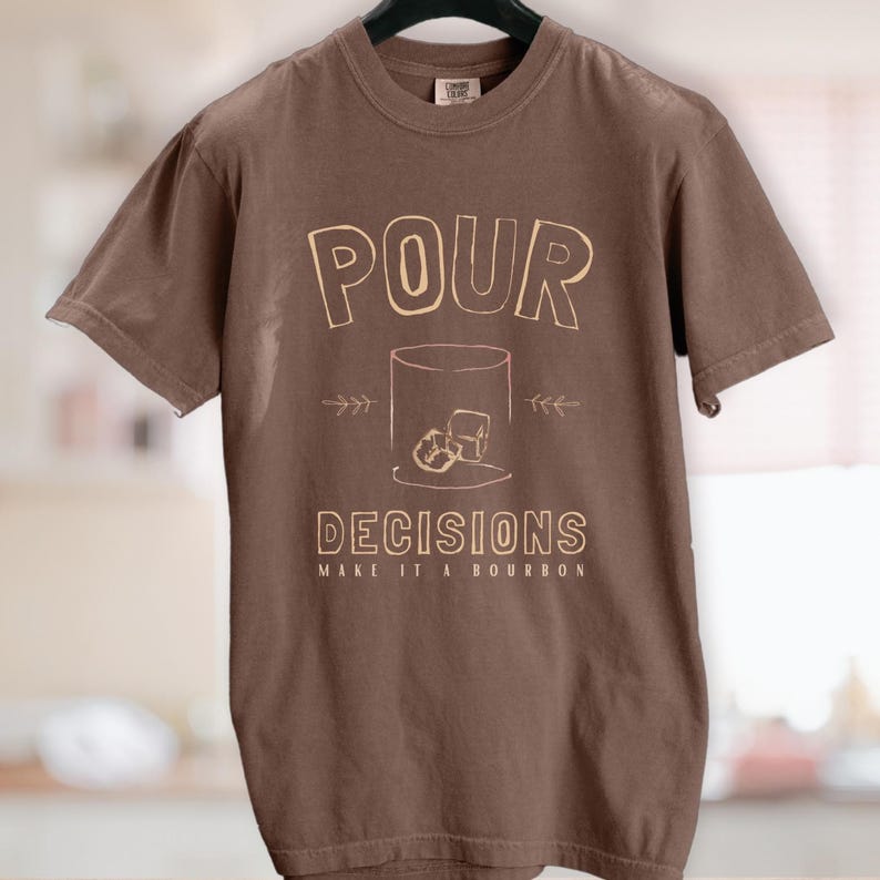 For the bourbon lovers! POUR DECISIONS (make it a bourbon) with a simple distressed line drawing of a whiskey glass with two ice-cubes. Cream graphics on espresso brown.