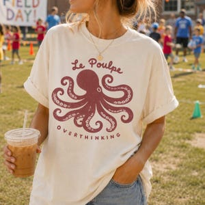 Woman wearing ivory Comfort Colors octopus graphic tee outdoors.