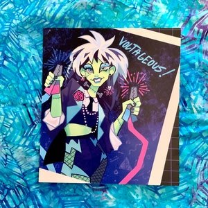 Pu&ograve; includere: Un'illustrazione digitale di una donna con la pelle verde e i capelli bianchi che indossa un abito nero e blu e tiene in mano due fuochi d'artificio. Il testo "VOLTAGEOUS!" &egrave; scritto in bianco su sfondo nero.
