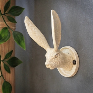 May include: A white ceramic rabbit head wall hook. The rabbit has a detailed, textured surface and a round base.