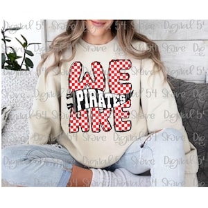 May include: A cream-colored sweatshirt with the words "WE ARE PIRATES" in a bold, checkered red and white design. The text is outlined in black, with a banner that reads "PIRATES" in white on a black background.