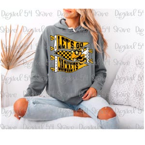 Pode incluir: Um moletom cinza com o texto "LET'S GO JACKETS" em amarelo e preto, com um mascote de abelha de desenho animado. O moletom tem um cordão e é usado com jeans azul claro.