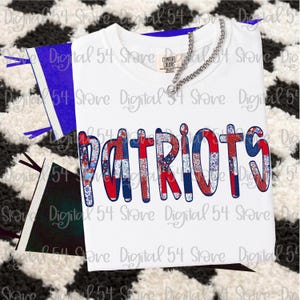 Könnte beinhalten: Weißes T-Shirt mit dem Wort "PATRIOTS" in rot-weiß-blauen Patchwork-Buchstaben. Das Shirt hat einen Rundhalsausschnitt und kurze Ärmel. Eine silberne Halskette liegt über dem Shirt.