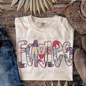 May include: Cream-colored t-shirt with the word "FAMILY" in a patchwork design of floral and patterned fabrics. The shirt has a crew neck and short sleeves. A casual, everyday wear item.