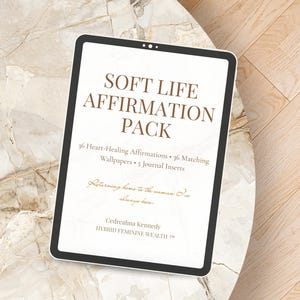 May include: A digital tablet displaying the text "SOFT LIFE AFFIRMATION PACK." The screen also lists "36 Heart-Healing Affirmations," "36 Matching Wallpapers," and "5 Journal Inserts." The tablet is on a marble-patterned surface.