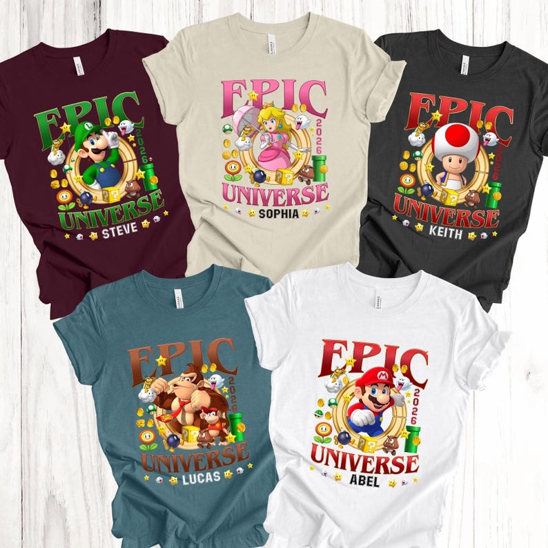 May include: Five short-sleeve t-shirts in maroon, cream, black, teal, and white, each featuring a graphic of a Super Mario character, the text EPIC UNIVERSE 2026, and a personalized name: Steve, Sophia, Keith, Lucas, or Abel, surrounded by game icons.