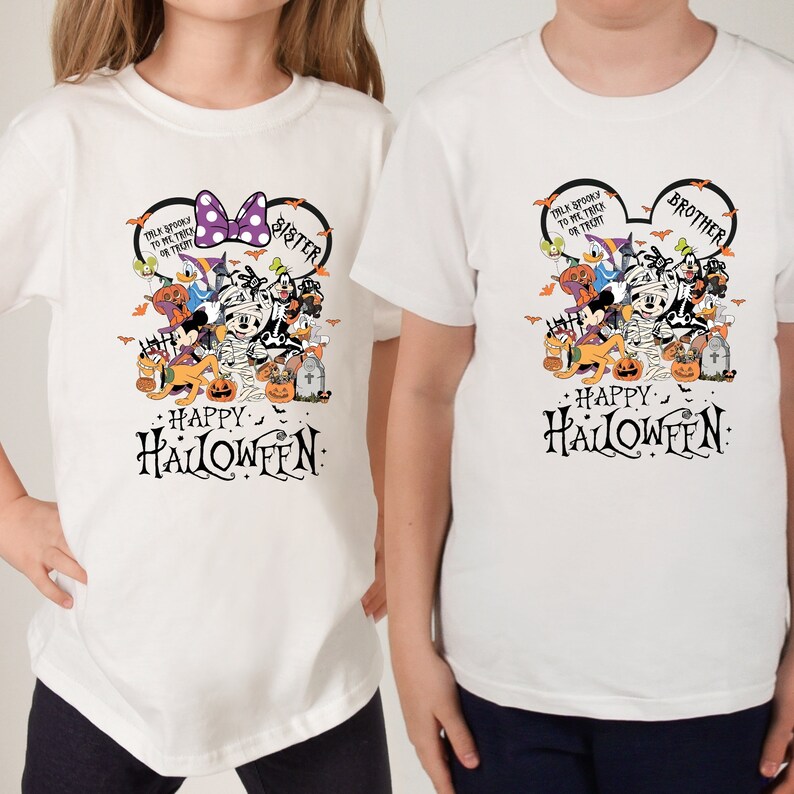 May include: White t-shirts featuring a Halloween-themed graphic. One shirt has a purple bow and the word "Sister", the other has the word "Brother". Both shirts display Disney characters and the text "Happy Halloween".