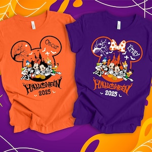 以下が含まれることがあります： ハロウィーンをテーマにした2枚のTシャツ。1枚はオレンジ色、もう1枚は紫です。どちらも、スケルトンのコスチュームを着たディズニーのキャラクターが描かれたミッキーマウスの頭のデザインが特徴です。オレンジ色のシャツには「Oscar」という名前、紫色のシャツには「Emily」という名前が書かれています。「Halloween 2025」の文字が下にあります。