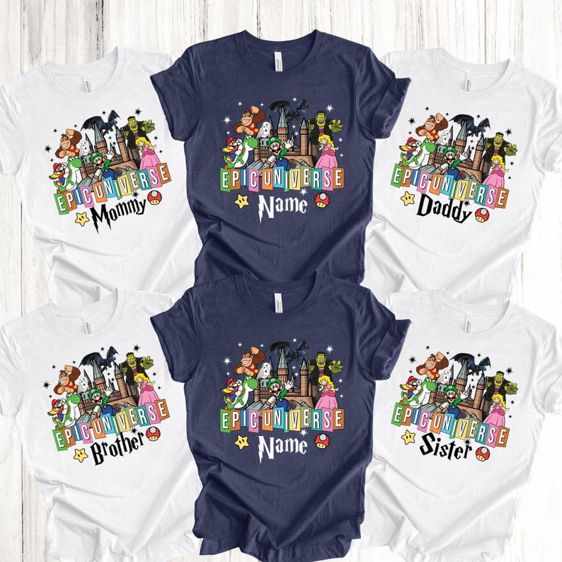 May include: A collection of white and navy blue t-shirts with colorful graphic designs. Each shirt features the text "EPICUNIVERSE" and a character design. Some shirts have additional text like "Mommy", "Daddy", "Brother", "Sister", and "Name".