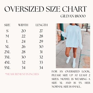 May include: Size chart for Gildan 18000 oversized sweatshirts, showing width and length measurements in inches for sizes S through 5XL. A model is wearing a white sweatshirt in size XL, standing on a sidewalk.