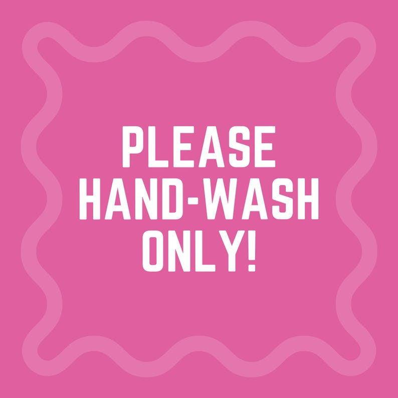 以下が含まれることがあります： 「PLEASE HAND-WASH ONLY！」という太字の白い文字が書かれた正方形のピンク色のサイン。サインには、波状の薄いピンク色のボーダーがあります。