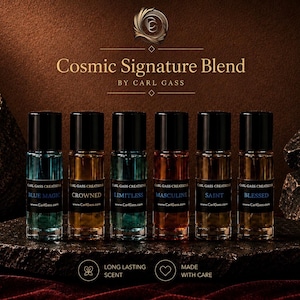 May include: Six perfume bottles with black caps and labels, arranged on a dark stone surface. The bottles contain various colored liquids, including blue, brown, and orange. The text "Cosmic Signature Blend" and "Carl Gass" are visible.
