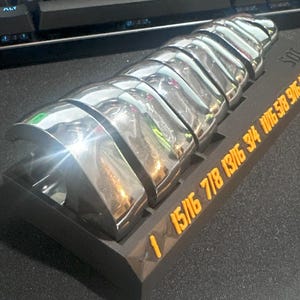 May include: A black and silver wrench set with 10 different sizes, including 15/16, 7/8, 13/16, 3/4, 1/16, 5/8, 9/16, 7/16, 1/2, and 9/16. The wrenches are arranged in a row on a black base with the sizes printed in orange.