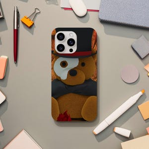 May include: A phone case with a brown teddy bear wearing a black top hat and a white eye patch. The bear is holding a red rose.