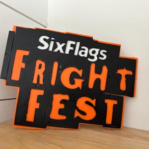 May include: Black and orange sign with the text "Six Flags Fright Fest" in a bold, stylized font.