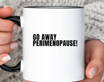 May include: White ceramic coffee mug with a black rim and handle. The mug has black text that reads "Go Away Perimenopause!"