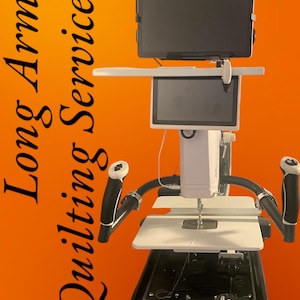 Puede incluir: Máquina de acolchado de brazo largo blanca y negra con una tableta y pantalla adjuntas. La máquina tiene manijas negras y una superficie de trabajo blanca. El texto "Long Arm Quilting Service" está en el lado izquierdo de la imagen.