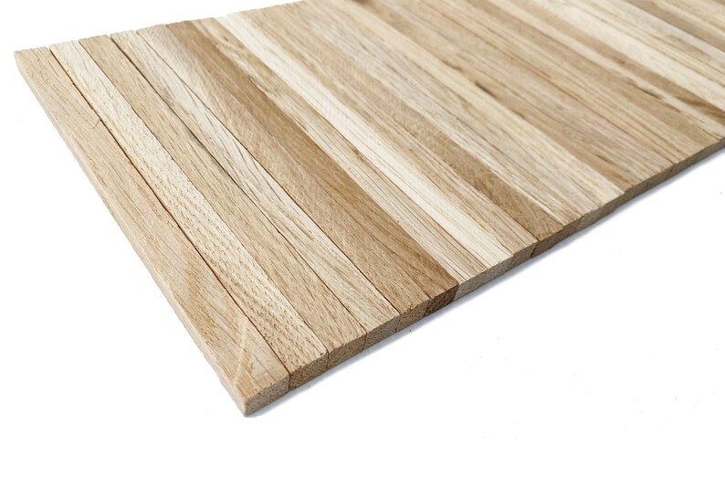 May include: A close-up of a wooden panel made of thin, light brown wood strips arranged horizontally. The panel is angled to show the edges of the strips.