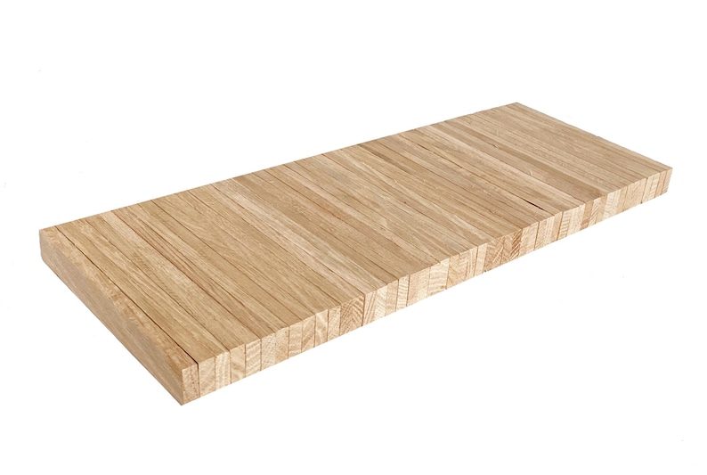 Op de afbeelding: Een lange, rechthoekige houten plank gemaakt van dunne, gestapelde latten hout. De plank is lichtbruin van kleur en heeft een natuurlijke hout afwerking.