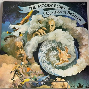 May include: A vintage vinyl record album cover featuring a colourful illustration of a hand reaching towards a globe surrounded by clouds. The album title is "The Moody Blues: A Question of Balance".
