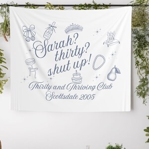 Może przedstawiać: Biały baner z niebieskim tekstem i ilustracjami. Tekst brzmi "Sarah? thirty? shut up!" i "Thirty and Thriving Club Scottsdale 2005". Ilustracje obejmują koronę, butelkę szampana, ciasto, gruszkę, naszyjnik i parę szpilek.