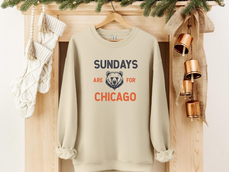 K&ouml;nnte beinhalten: Ein beiger Pullover mit dem Aufdruck "SUNDAYS ARE FOR CHICAGO" auf der Vorderseite. Ein B&auml;renkopf befindet sich in der Mitte des Textes.