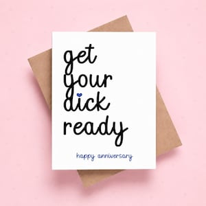 Pode incluir: Um cartão branco com o texto "get your dick ready" em escrita preta, um coração azul e "happy anniversary" em azul. O cartão está sobre um envelope castanho, sobre um fundo rosa.