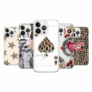 May include: Five different phone cases with various designs. The first case has a white background with brown stars. The second case has a black and white design with a building, lips, and a disco ball. The third case has a white background with a black spade and a leopard print. The fourth case has a white background with a disco ball, cherries, and a red heart. The fifth case has a brown leopard print.