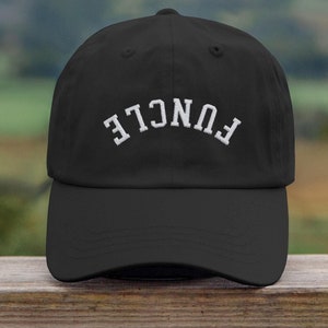 May include: A black baseball cap with white embroidered text that reads "FUNCLE" in a backwards arc.