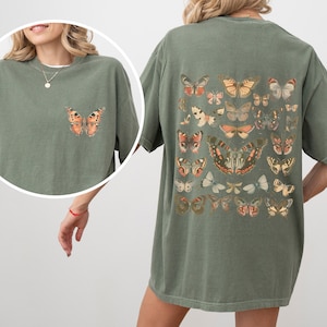May include: An oversized green t-shirt with a vintage butterfly print on the back. The shirt has a relaxed fit and a crew neck.
