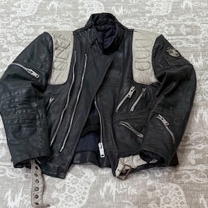 May include: A set of three ceramic mugs with a speckled, matte finish. The mugs are in shades of cream, light gray, and dark gray. Each mug has a simple, minimalist design, perfect for coffee or tea.