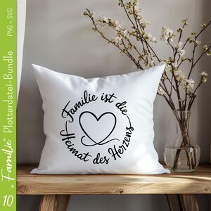 May include: White pillow with black text that reads "Familie ist die Heimat des Herzens" with a heart in the center of the text.