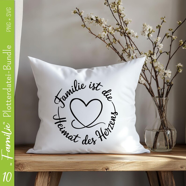 May include: White pillow with black text that reads "Familie ist die Heimat des Herzens" with a heart in the center of the text.