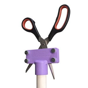 May include: Purple plastic pipe clamp with a pair of black scissors attached. The clamp has the text "PrecisionX Do Not Overtighten" printed on it. The pipe is 3/4 inch in diameter.