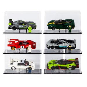 May include: Six miniature Lego car models displayed in clear acrylic display cases. The cars are a red Ferrari 512 M Sport, a green Aston Martin Valkyrie AMR Pro, a white Lamborghini Countach, a green Mercedes-AMG Project One, a green Aston Martin Valkyrie AMR Pro, and a gray McLaren Senna.
