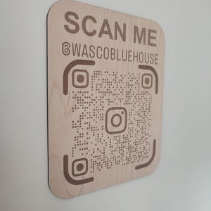 Peut inclure: Une pancarte en bois avec un code QR et le texte "SCAN ME @WASCObluehouse".