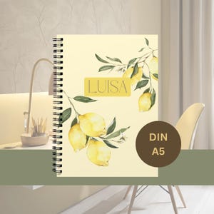 Könnte beinhalten: Ein gelbes Notizbuch mit Spiralbindung und einem Zitronenzweig-Design. Das Notizbuch trägt den Namen "LUISA" auf der Vorderseite. Das Notizbuch ist mit "DIN A5" gekennzeichnet.