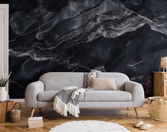 May include: A stylish living room with a grey sofa, wooden furniture, and a striking black marble feature wall. A woven basket, a white door, and a decorative rug are also present. The room is decorated in neutral tones, creating a calm and inviting atmosphere.