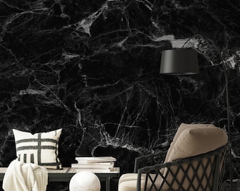 May include: A black and white marble wallpaper with a brown wicker chair, a white throw blanket, a black and white pillow, and a white round table with a white sphere on top.