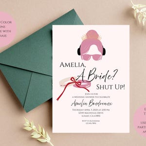 May include: A wedding shower invitation with the text "Amelia, A Bride? Shut Up!" features a pink illustration of a woman with headphones and sunglasses. Includes an envelope and text about the event.
