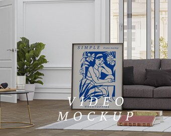 May include: A framed video mockup with a blue and white illustration of a woman sitting in a garden. The frame is black and has the text "SIMPLE Frame mockup" and "VIDEO MOCKOPTIRE" on it.