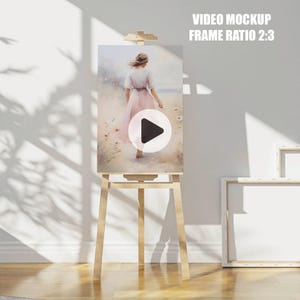 May include: A wooden easel with a canvas displaying a watercolor painting of a woman walking on a beach. The canvas is on a white background with a play button icon in the center.