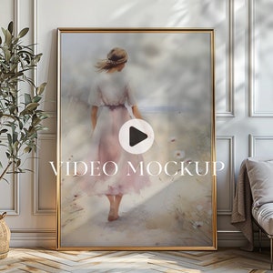 以下が含まれることがあります： ピンクのドレスを着た人が海に向かって歩いている水彩画が描かれた、額入りのアートプリント。アートワークは金のフレームに収められ、「VIDEO MOCKUP」というテキストが含まれています。全体的な美しさは柔らかく、夢のようです。