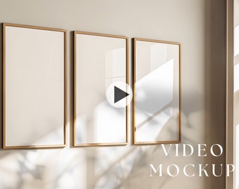 May include: Three gold-framed picture frames on a light beige wall with a window in the background. The frames are empty and ready for your video content. The text "VIDEO MOCKUP" is at the bottom of the image.