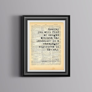 May include: A black framed print with a vintage book page background featuring the lyrics "Someday you will find me caught beneath the landslide in a champagne supernova in the sky." from the Oasis song "Champagne Supernova".
